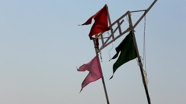 The colorful flags on the fishing boat flutter in the wind