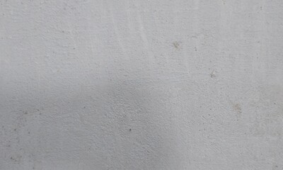Fototapeta premium Colorful stains under crumbling gray paint on shabby wall of grungy building on street.Old concrete background for wallpaper.Texture of old dirty Rough Peeled concrete wall for scratched Background.