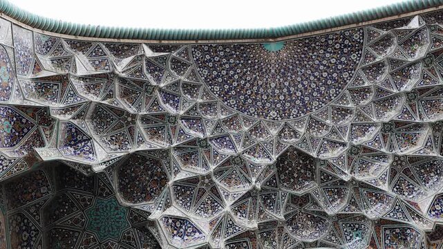 Decorated ceiling of the Imam Mosque with intricate blue tile patterns and geometric ornament. Persian Islamic architecture inside Imam Mosque at Naqsh-e Jahan Square, Isfahan, Iran, showing detailed 