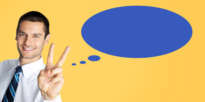 Portrait image - happy business man businessman wear formal shirt, tie shows points two fingers or v victory gesture, isolate yellow background. Blue empty speech bubble speechbubble, cloud ballon