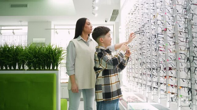 Mother helping son choose new eyeglasses
