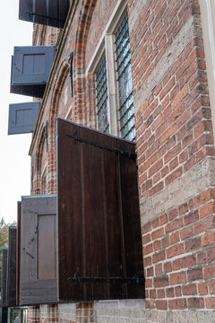 Old brick building fa&ccedil;ade with wooden shutters in zutphen