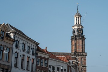 Fototapeta premium Drogenapstoren clock tower rising above zutphen buildings