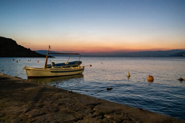 Small boats in a harbor after sunset