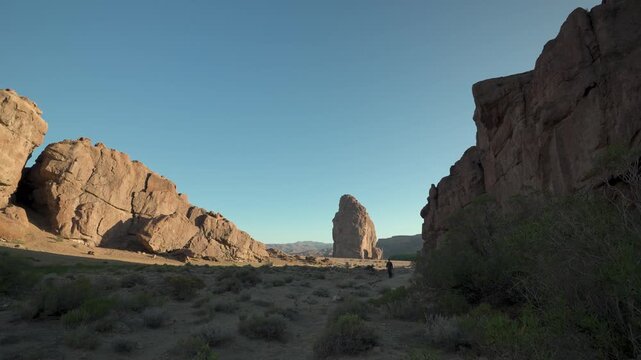 Silhouette of a man walking through the vast canyon landscape of the Piedra Parada natural protected area in Patagonia, Argentina