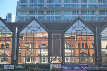 Obraz premium modern building at 423-425 Queen W, with reflection of heritage buildings in windows and condo tower rising up behind, Toronto