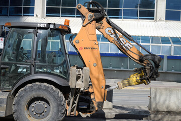 Obraz premium CASE Extendahoe, a telescoping backhoe dipper arm designed for increased reach and dig depth, often fitted with a CASE Hydraulic Breaker (Rock Hammer) using a Moil Point bit for concrete and rock demo