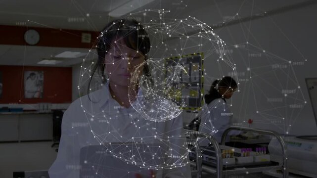 Nurse looking down at tablet, tapping and glancing, watching rotating network globe guiding prep