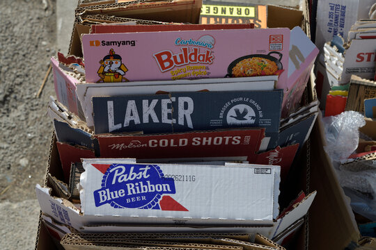 bundles of cardboard boxes with labels showing including Pabst Blue Ribbon, Molson Cold Shots, Laker, and Buldak, Toronto