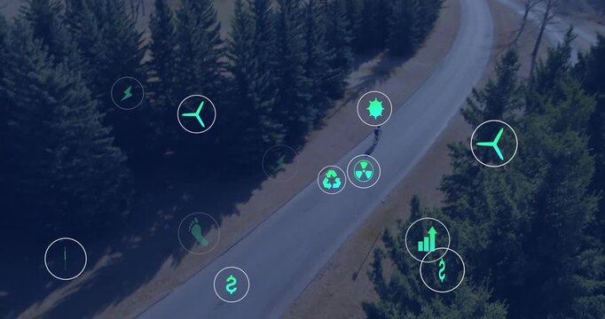 Riding helmeted cyclist in gear pedaling bike along road by pines, drone rising showing teal icons