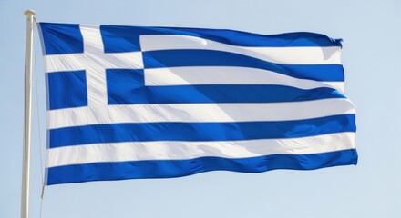 The national flag of greece waving in the wind against a clear sky background.