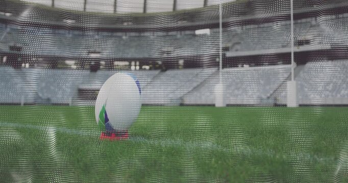Rugby ball sitting on red tee camera pulling back revealing goalposts mesh thinning preparing kick