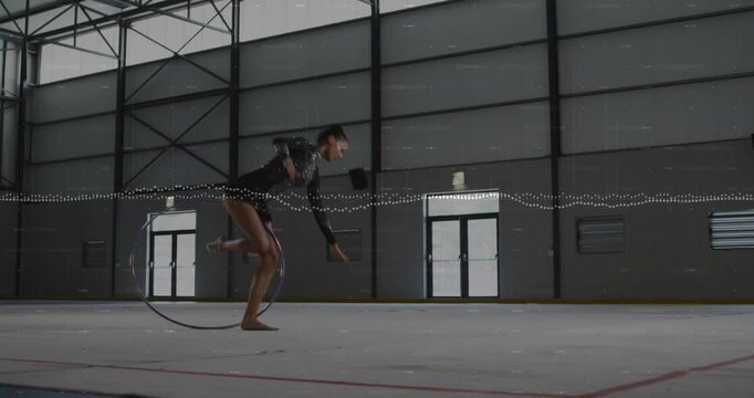 Woman gymnast nearing hoop, rolling, leaping through, tumbling, waveform syncing, finishing routine