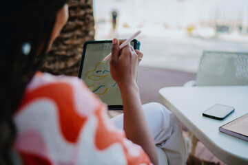 Close-up of woman drawing on tablet with stylus, showing modern creativity, independence, and innovation with mobile technology tools in digital art and design workflow.