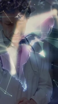Vertical video: Dr reading paper with steth as cam panning sparking globe around torso showing care