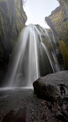 Portret spływającego wodospadu po czarnej skale  © Asnyko