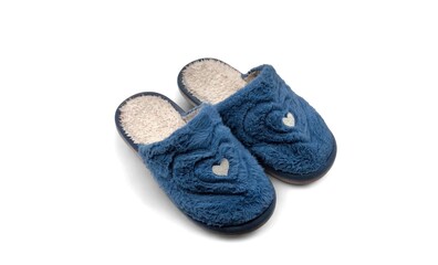 Top view of a pair of soft blue fluffy house slippers with warm fleece lining and small heart detail, isolated on white background. © Antonios