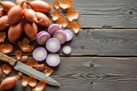 Fresh shallots whole and sliced with knife and peels on rustic wooden background with copy space
