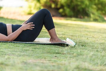 Fototapeta premium Close-up of a woman resting on a mat during an outdoor yoga session