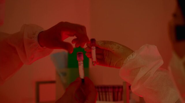 close up of scientist hand using yellow micropipette to transfer liquid into centrifuge tube in lab