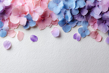 Obraz premium Pastel Hydrangea Petals Border on Textured White Paper — Soft Pink, Blue and Purple Florals for Wedding Invitations, Cards and Stationery