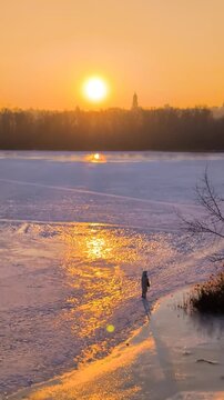 Beautiful sunset view of Kyiv in winter with frozen Dnipro River