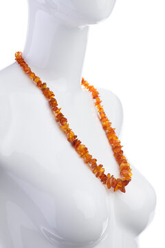 Raw Baltic amber beads necklace on mannequin isolated on white background