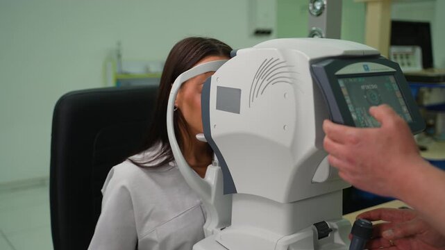 Woman undergoing eye examination with autorefractor keratometer