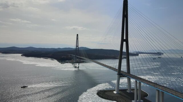 Cable-stayed Russky Bridge in Vladivostok, Russia, connecting Russky Island with the mainland over the Eastern Bosphorus Strait. Winter view with sea partially covered with ice.