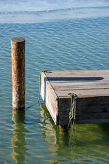 Fototapeta premium Wooden dock and mooring post in calm water