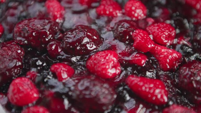Juicy berries cooking gently, Kitchen scene showing berry compote with steaming and stirring, Closeup of chef preparing fruit dessert with rich glaze and bubbling heat