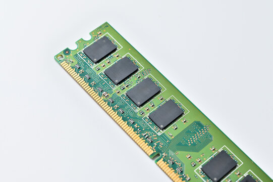 Close-up of a green computer RAM module with black memory chips on a white background