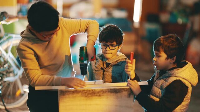 Three young brothers learning woodworking together