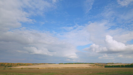 A stunningly beautiful landscape featuring a bright blue sky adorned with soft, fluffy clouds
