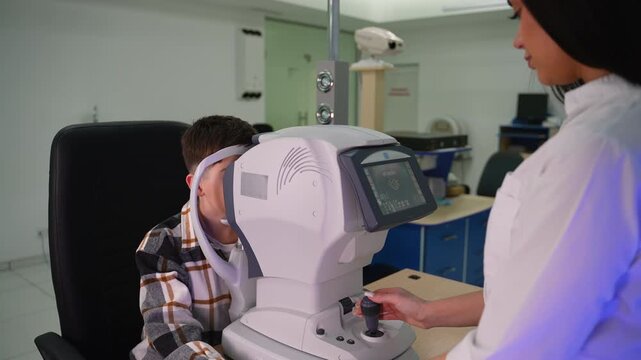 Female ophthalmologist examining patient's eyesight with autorefractor