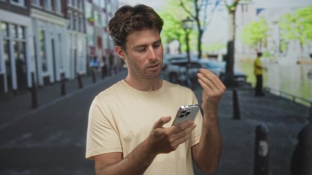 Man holding smartphone with one hand and left hand raised in questioning gesture on a city street; frustration.