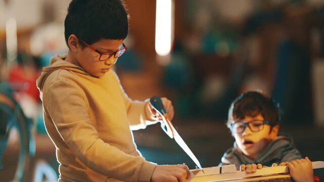 Young boys learning woodworking skills in workshop