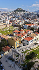 Naklejka premium Aerial drone portrait photo of ancient Roman Market featuring tower of Winds and Gate of Athena in the heart of Athens historic centre built in Plaka district, below Acropolis hill, Attica, Greece