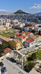Naklejka premium Aerial drone portrait photo of ancient Roman Market featuring tower of Winds and Gate of Athena in the heart of Athens historic centre built in Plaka district, below Acropolis hill, Attica, Greece
