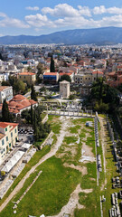 Naklejka premium Aerial drone portrait photo of ancient Roman Market featuring tower of Winds and Gate of Athena in the heart of Athens historic centre built in Plaka district, below Acropolis hill, Attica, Greece
