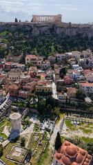 Naklejka premium Aerial drone portrait photo of ancient Roman Market featuring tower of Winds and Gate of Athena in the heart of Athens historic centre built in Plaka district, below Acropolis hill, Attica, Greece