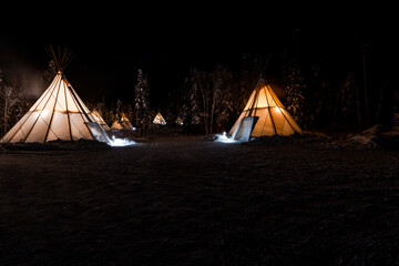 Illuminated teepees in night winter landscape, Canadian Northern Territories near Yellowknife. Canada © beataaldridge
