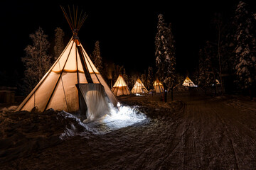 Illuminated teepees in night winter landscape, Canadian Northern Territories near Yellowknife. Canada © beataaldridge