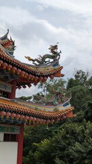 Fototapeta premium Colourful chinese temple interior in Kuala Lumpur Malaysia with ornate gold buddha statue sculpture, detailed oriental artwork and sacred taoism buddhism architecture in famous cultural heritage