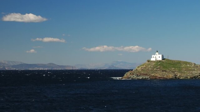 Wide view of Korissia Bay on Kea Island in the Cyclades, Greece, with the lighthouse visible on the headland and wind driven waves across the Aegean Sea, filmed in late winter to early spring with nat