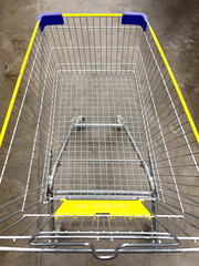 Empty shopping cart on concrete floor ready for groceries