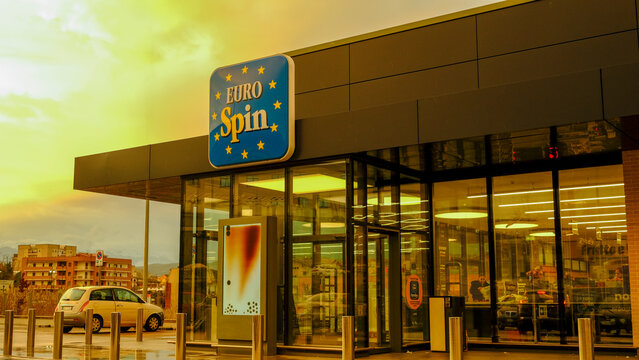 ITALY - MARCH 2026: Entrance of a Eurospin supermarket at sunset with its iconic blue and yellow logo visible on the facade.