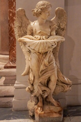 Marble sculpture of an angel holding a shell, used as a holy water font in Catholic churches.