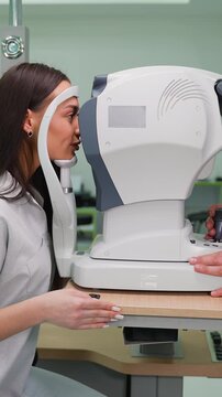 Woman undergoing eye examination with autorefractor keratometer