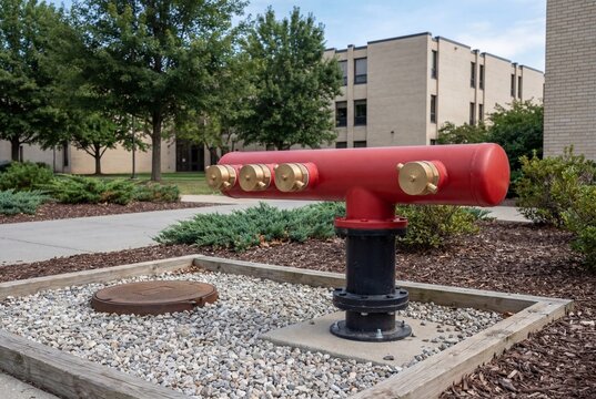 Red fire department connection manifold outside a commercial building
